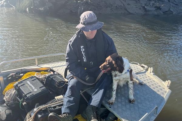 Police dog and handler on a boat.