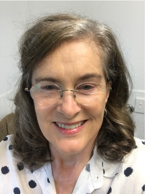 a smiling woman with grey hair and glasses