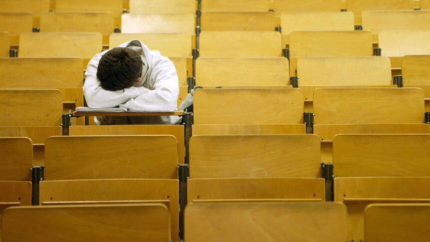 A student naps in a lecture hall