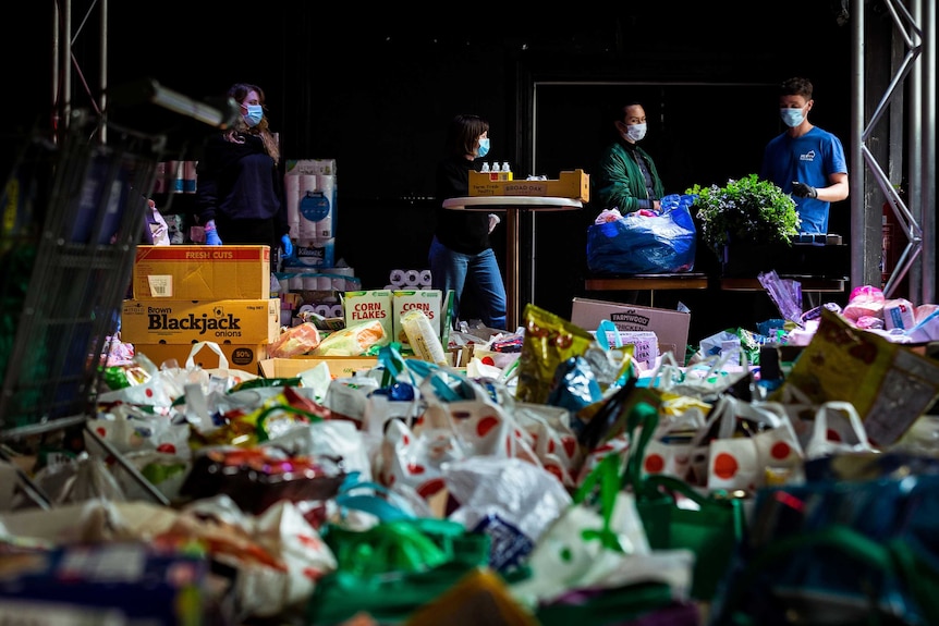 Volunteers in Melbourne sort through donated food for residents in public housing during enforced lockdown.