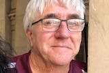 A man with grey hair and glasses