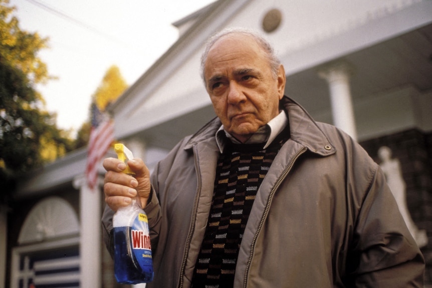 Michael Constantine as Greek patriarch Gus Portokalos holding a bottle of Windex.