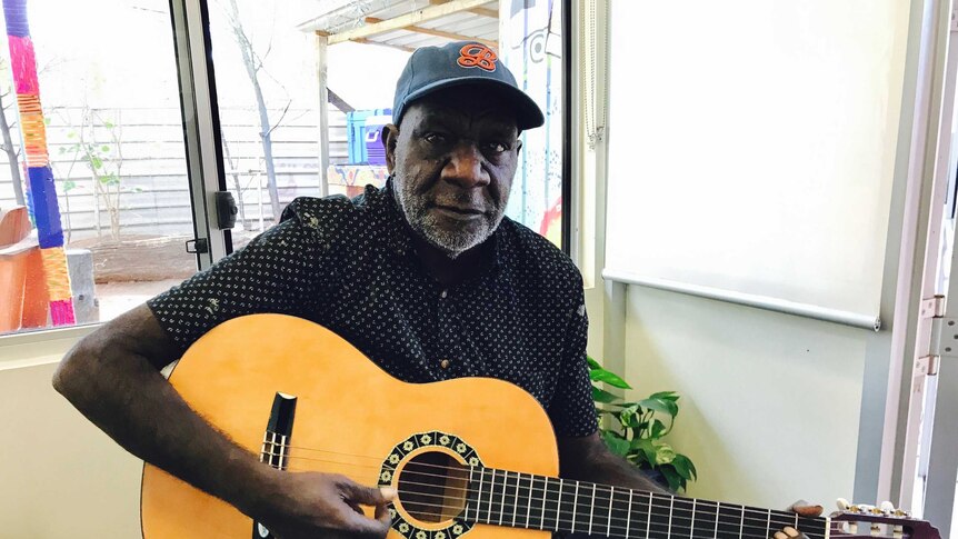 Dialysis patient, Quentin Jurrah sitting down playing a guitar