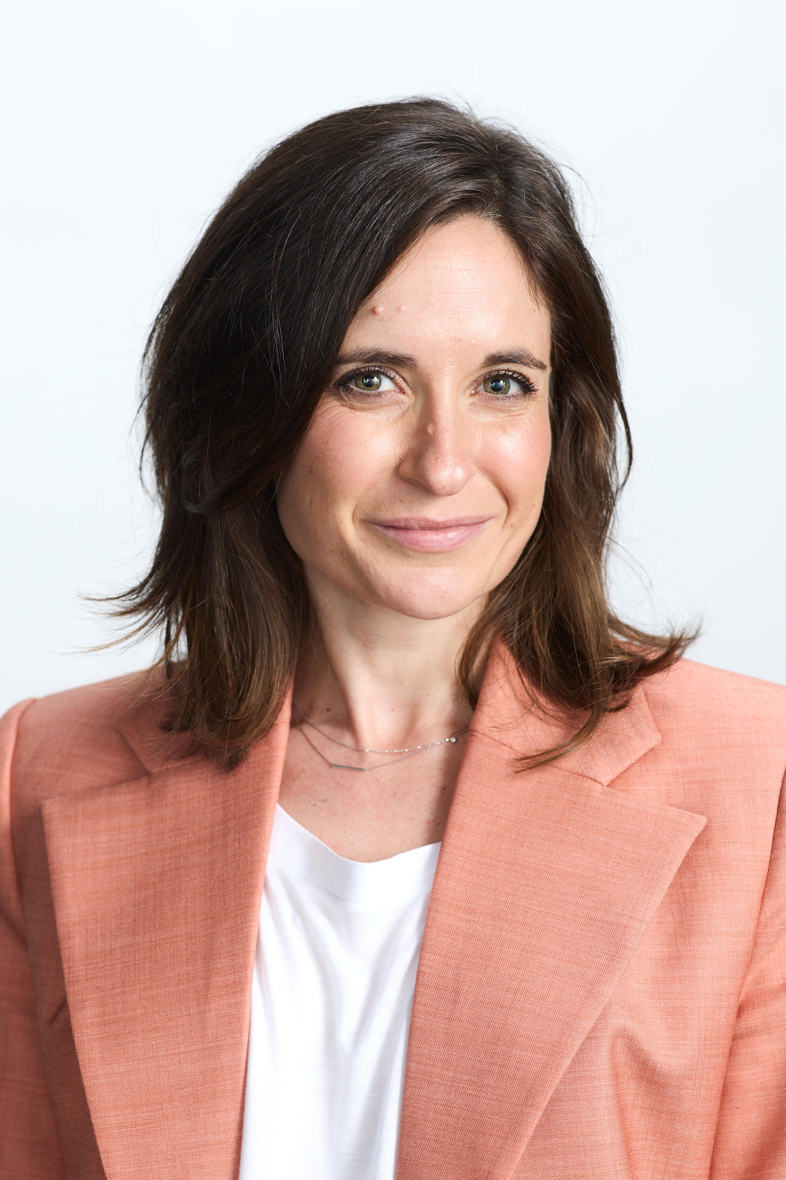 Bronwyn Graham, wearing a pink jacket and white shirt, smiles.