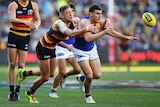 Adelaide's Hugh Greenwood tackles West Coast's Luke Shuey