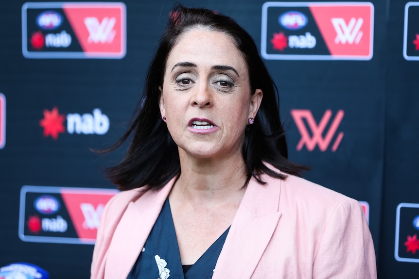 Nicole Livingstone speaks to media in front of the AFLW and NAB logos