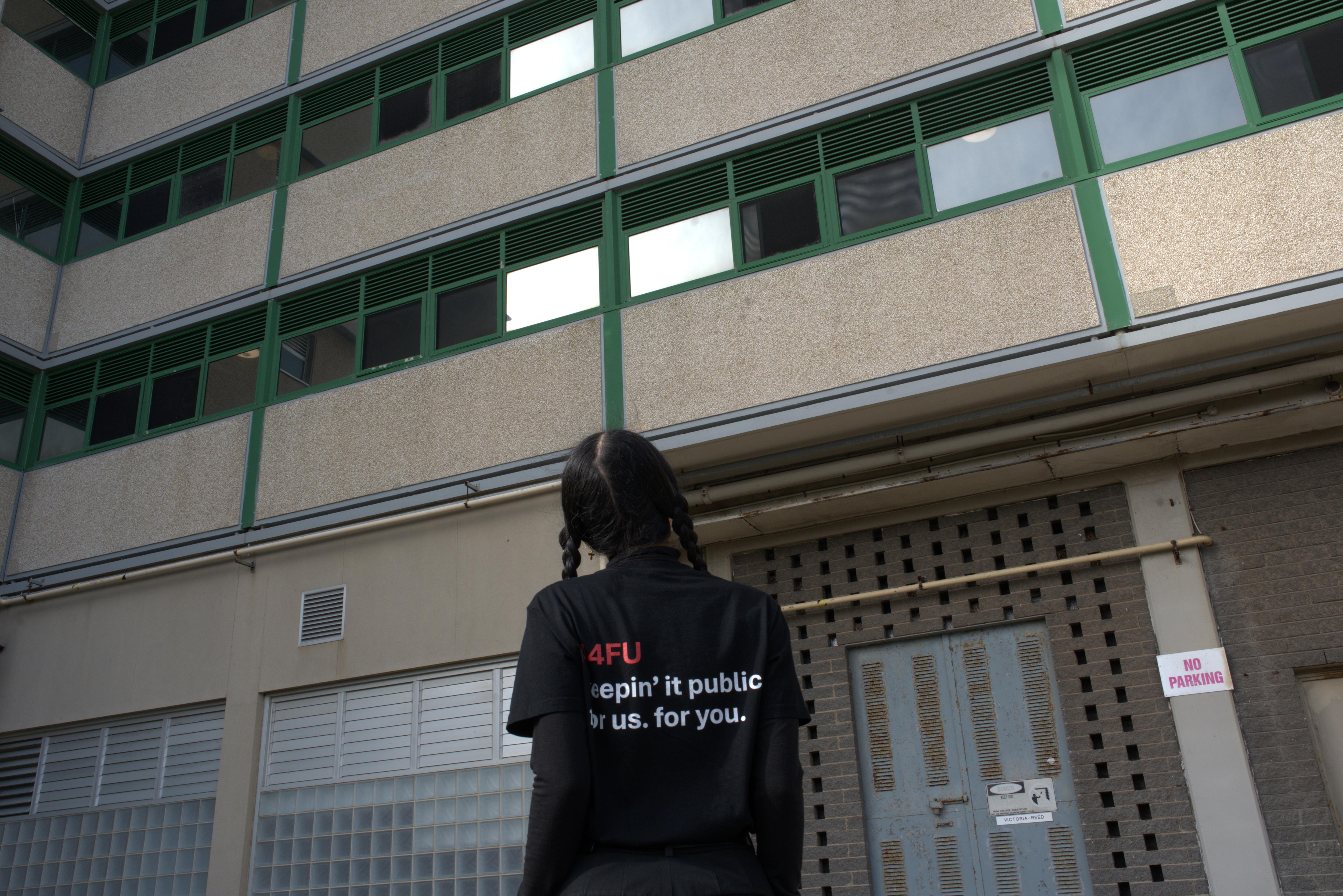 A 4FU female spokesperson with pigtails hair looks at tower block