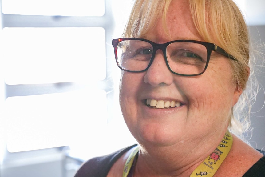 A headshot of a smiling blonde woman with glasses, Kerry Owens