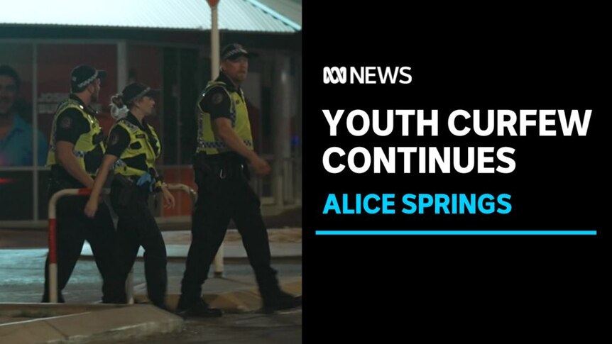 Youth Curfew Continues, Alice Springs: Three police officers in high vis patrol a street at night.