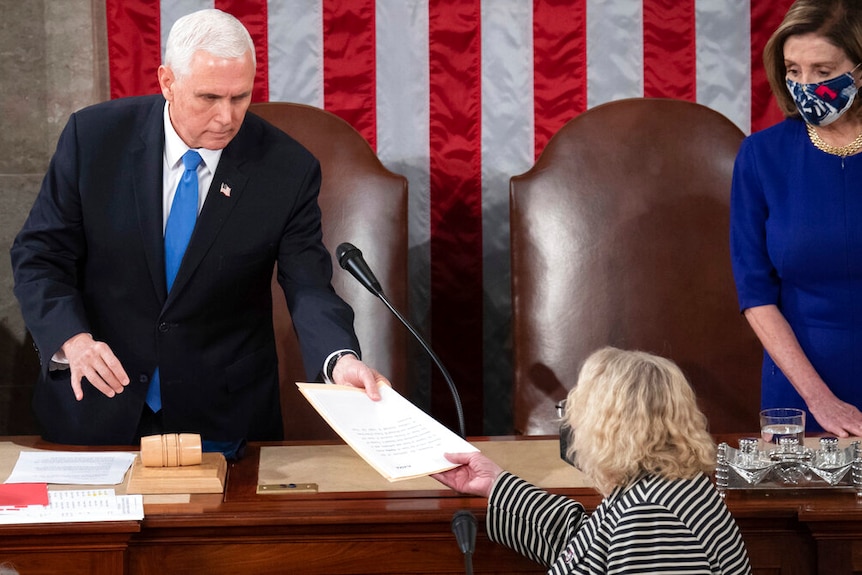 Vice President Mike Pence hands the electoral certificate during a joint session of Congress to count Electoral College votes.