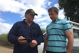 A farmer and university researcher look over irrigation software on a smartphone