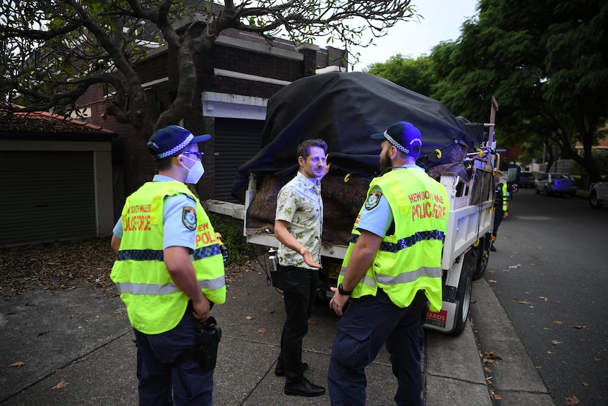 Police officers stop a truck