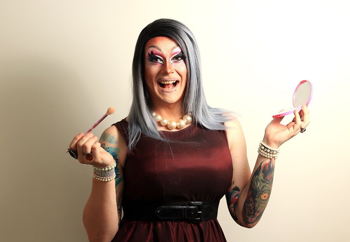 Wollongong drag queen Roxee Horror applies makeup and smiles.