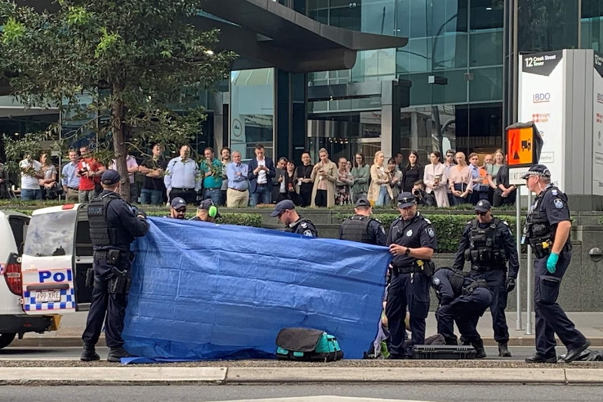 Police use a tarp to shield the view of protesters as they are cut from fencing.