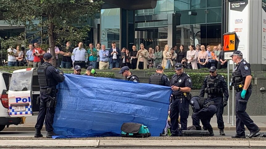 Police use a tarp to shield the view of protesters as they are cut from fencing.