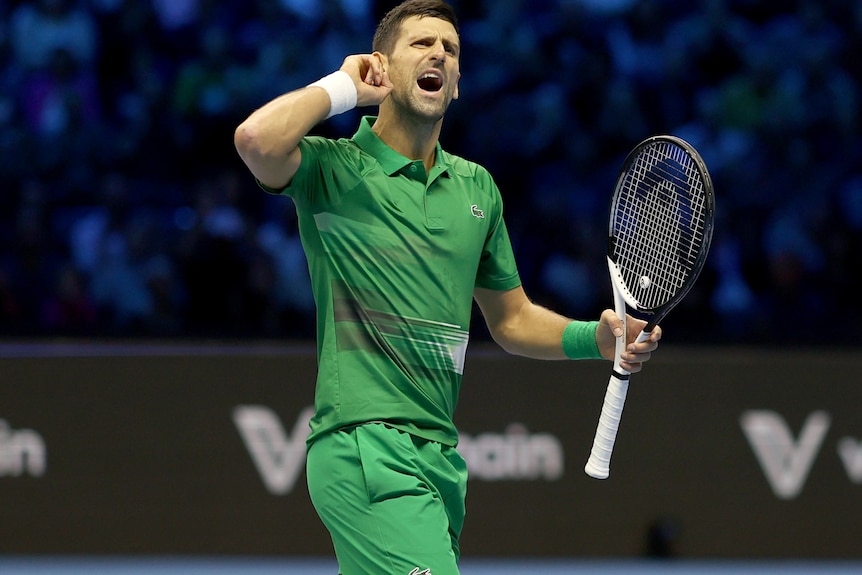 Novak Djokovic pointe son oreille en regardant vers la foule