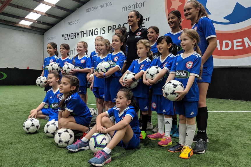 Membes of the Football Star Academy pose for a photo with Emma Checker.