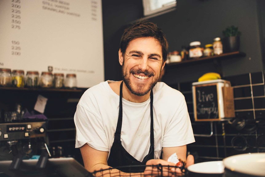 Portrait of happy barista at espresso bar.