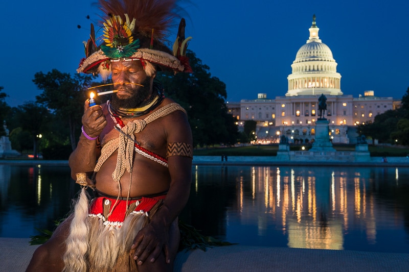 Huli chief Mundiya Kepanga lights a cigarette in front of the Reflecting Pool, Washington DC