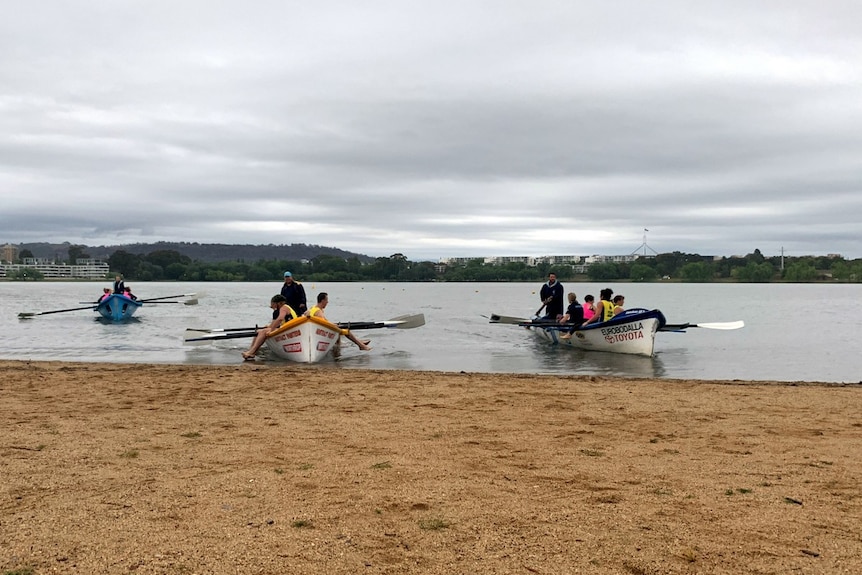 Three surf boat crews out on Lake Burley Griffin on a rainy Canberra day.