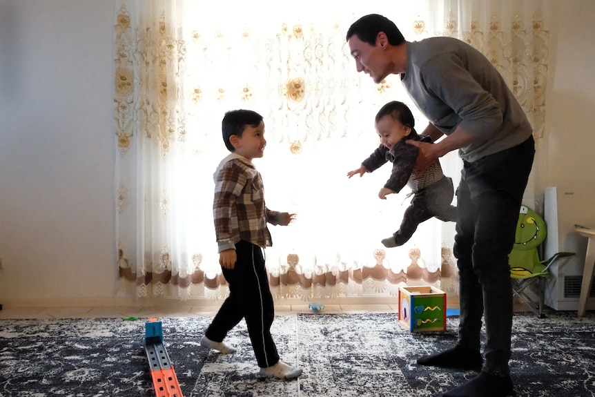 Sadam Abdusalam with his sons Lutfi and Latif with soft light from curtain in background.