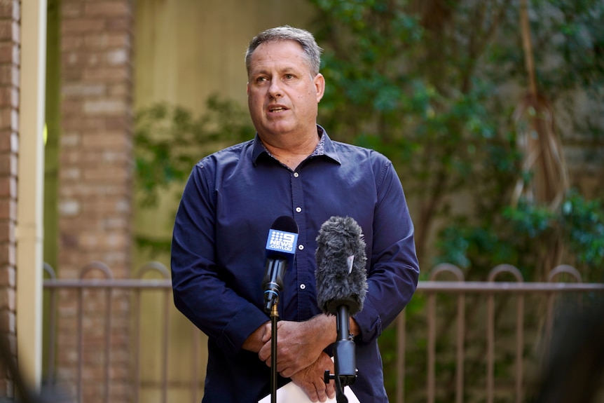 A man talks to the media at a press conference