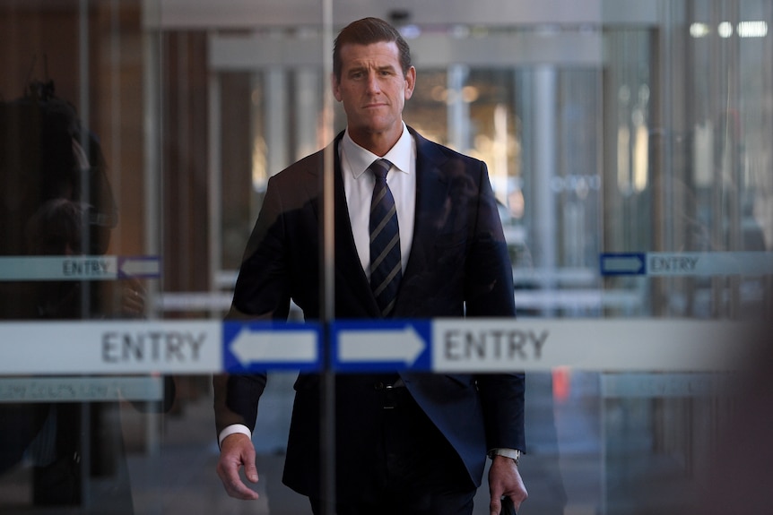 a man in a suit approaching sliding glass doors