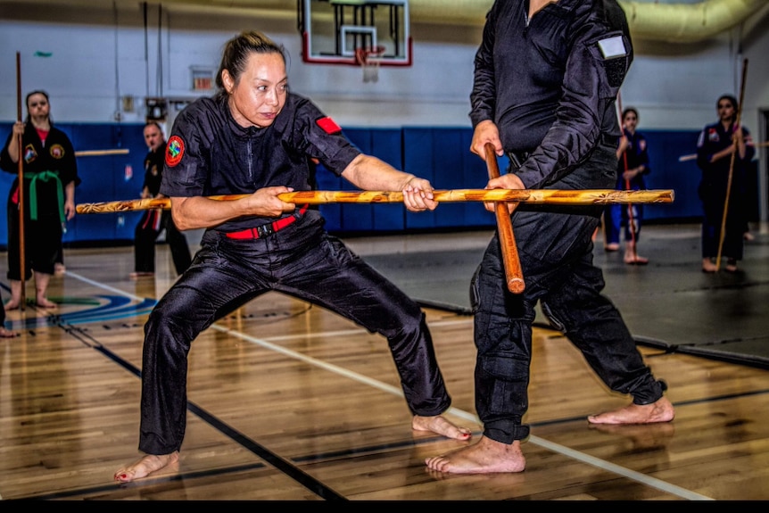 Lua Kumu Michelle Manu demonstrating with weaponry during a class.
