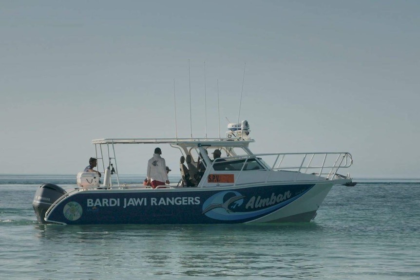 People stand on ranger boat at sea