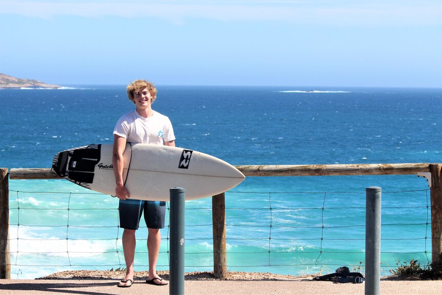 He stands with his board at the West Beach car park