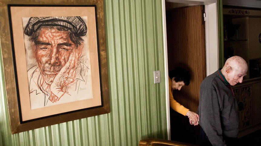 Marcos leads his wife Monica, who suffers from Alzheimer's disease, into their living room.