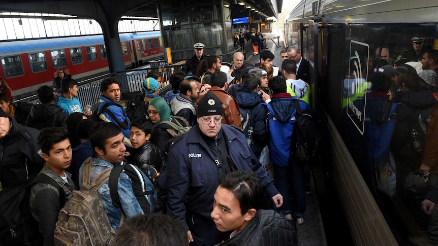 Asylum seekers try to get into a train.