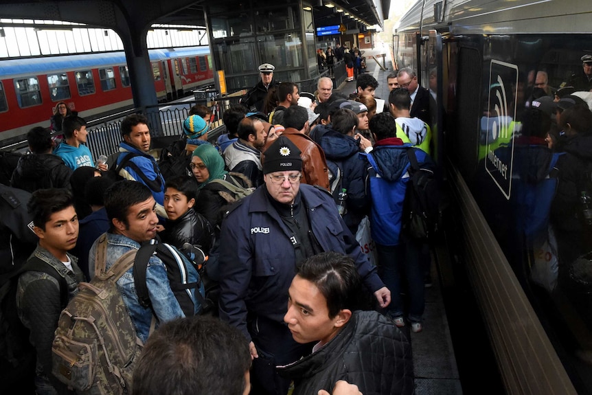 Asylum seekers try to get into a train.