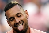 A male tennis player sticks his tongue out as he smiles at the Australian Open.