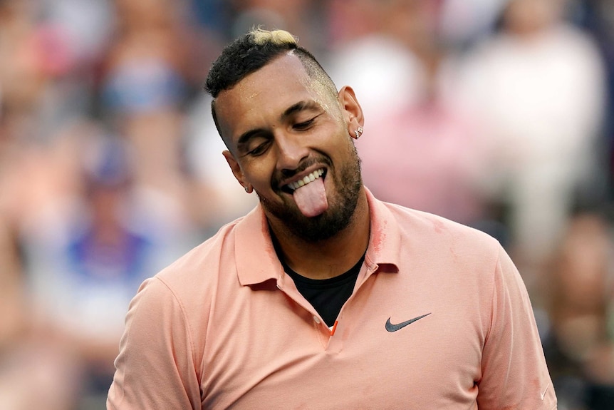 A male tennis player sticks his tongue out as he smiles at the Australian Open.