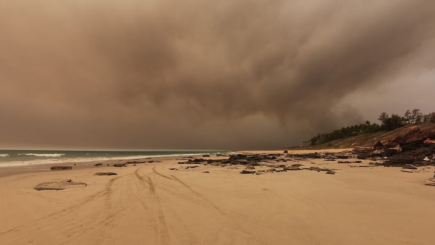 A wide shot from Cable Beach, pointed towards Coconut Wells. The sky is dark and and smoke is in the air