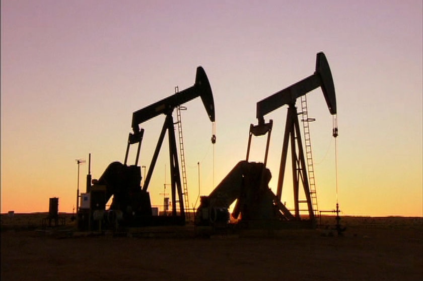 A silhouette of gas jacks or nodding donkeys pumping gas.