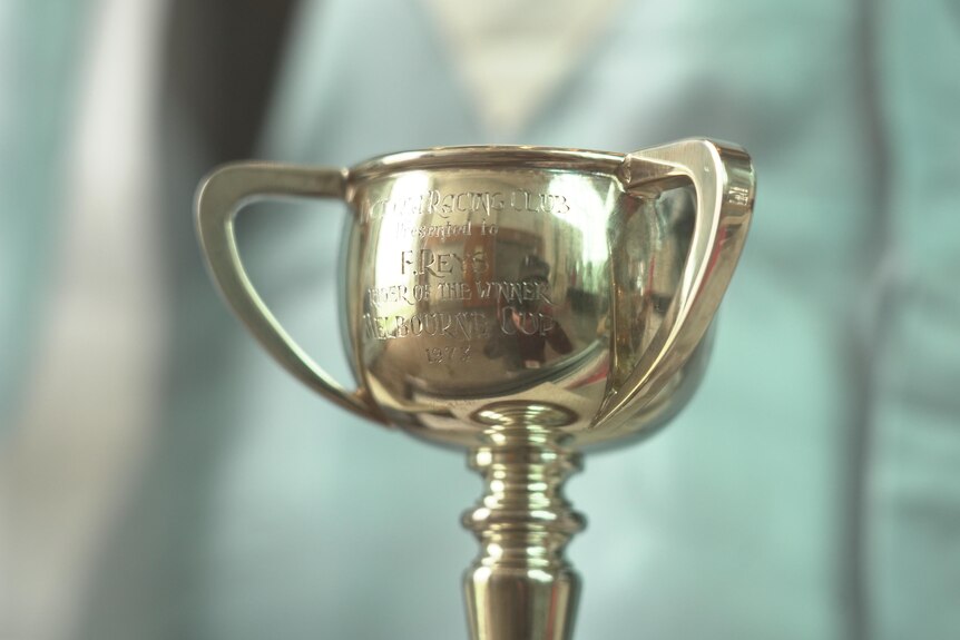 A small gold cup trophy with 'F.Reys' engraved on it