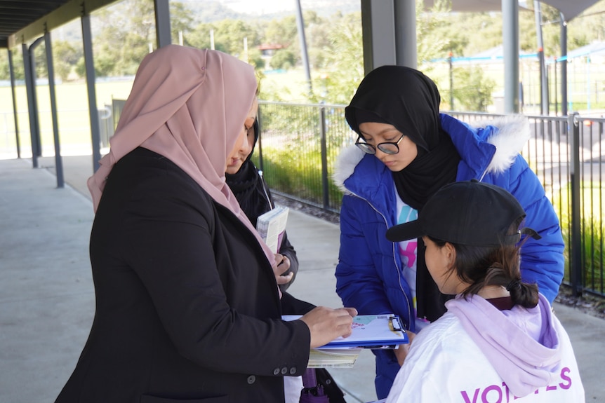Fatima and other volunteers look over a map to work out their doorknocking route.
