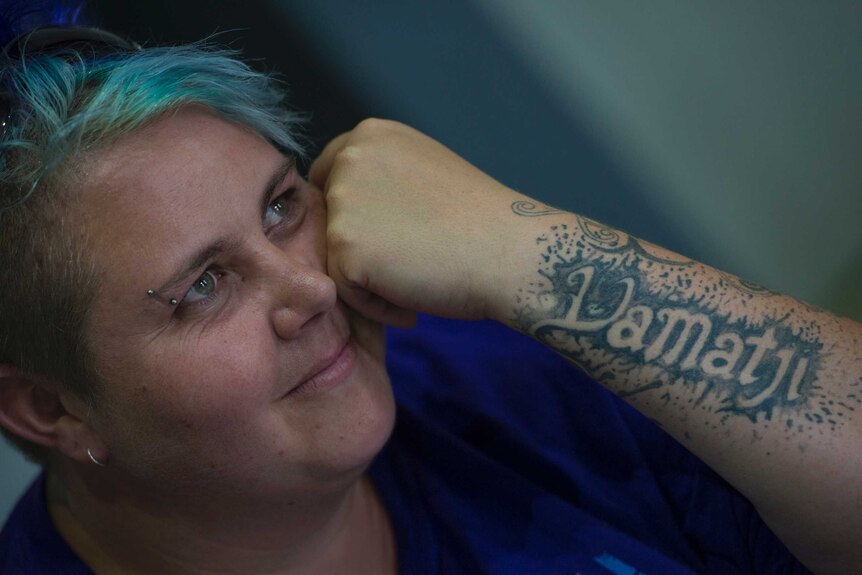 Yirra Yaakin artistic director Eva Grace Mullaley with blue hair and a tattoo on her arm that says "Yamatji"