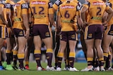 Brisbane Broncos stand in a huddle during an NRL match