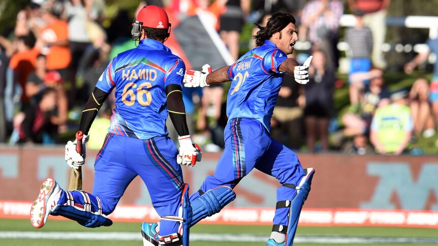 Afghanistan batsmen Shapoor Zadran (R) and Hamid Hassan celebrate after their win over Scotland.