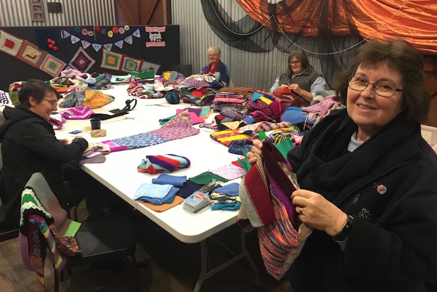 Group of women knitting squares.