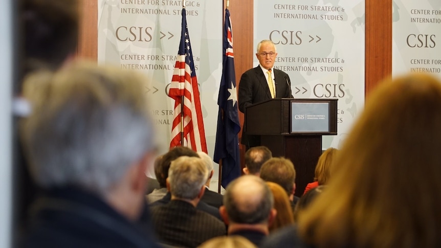 Photo through audience of Malcolm Turnbull speaking at a podium.