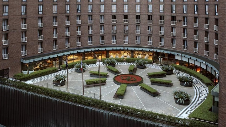 the exterior of a hotel with a garden and restaurant