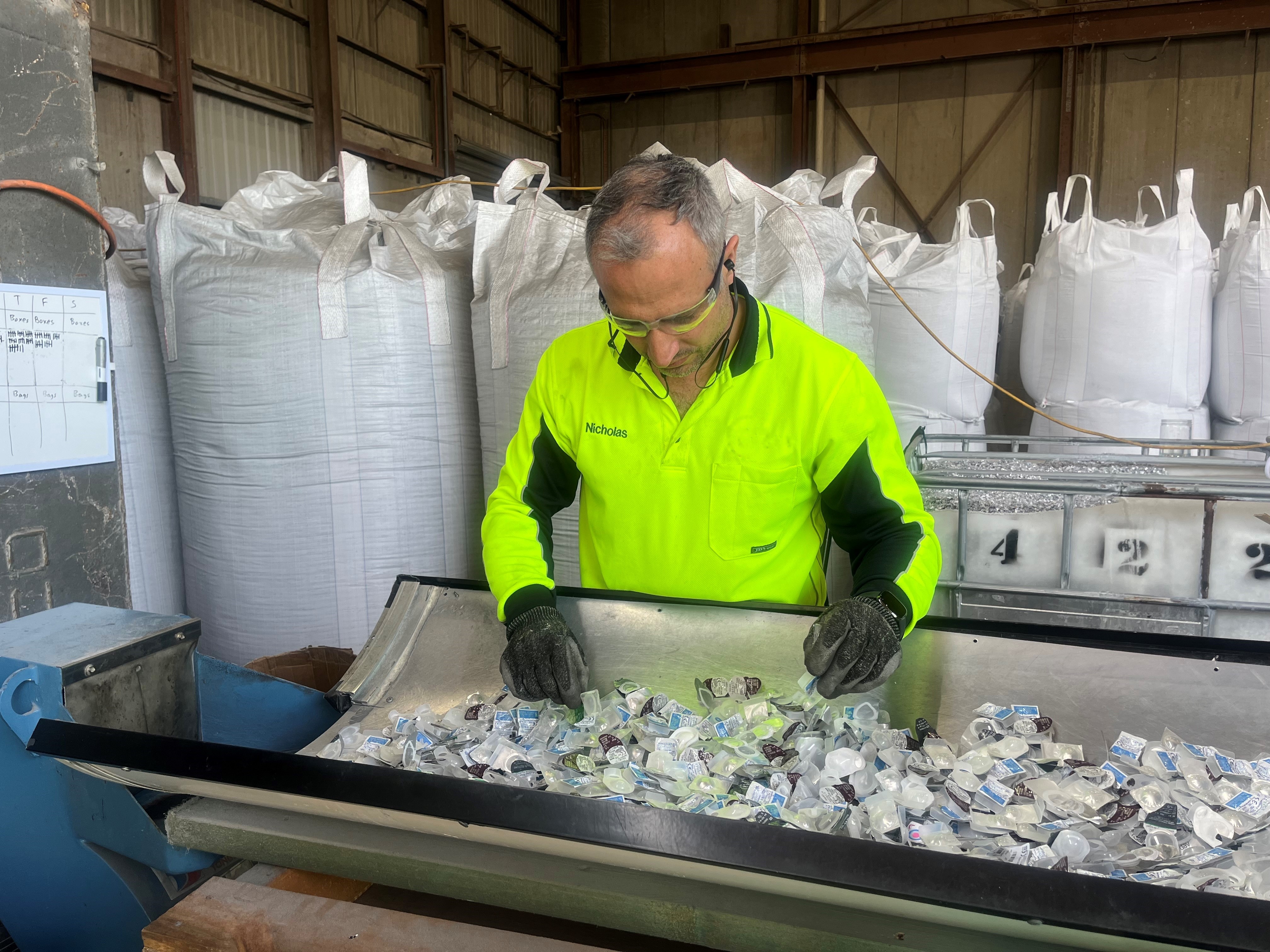 A worker in a hi-vis shirt recycles contact lenses.