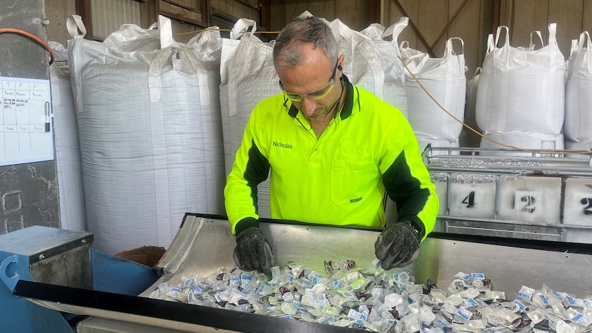 A worker in a hi-vis shirt recycles contact lenses.