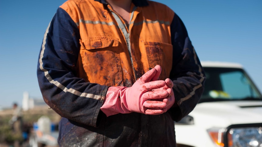 A man wearing gloves covered in whale oil and blubber