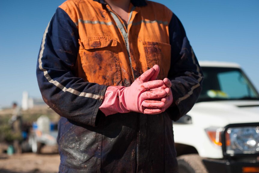 A man wearing gloves covered in whale oil and blubber