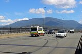 An ambulance passes burnout marks on the Tasman Bridge